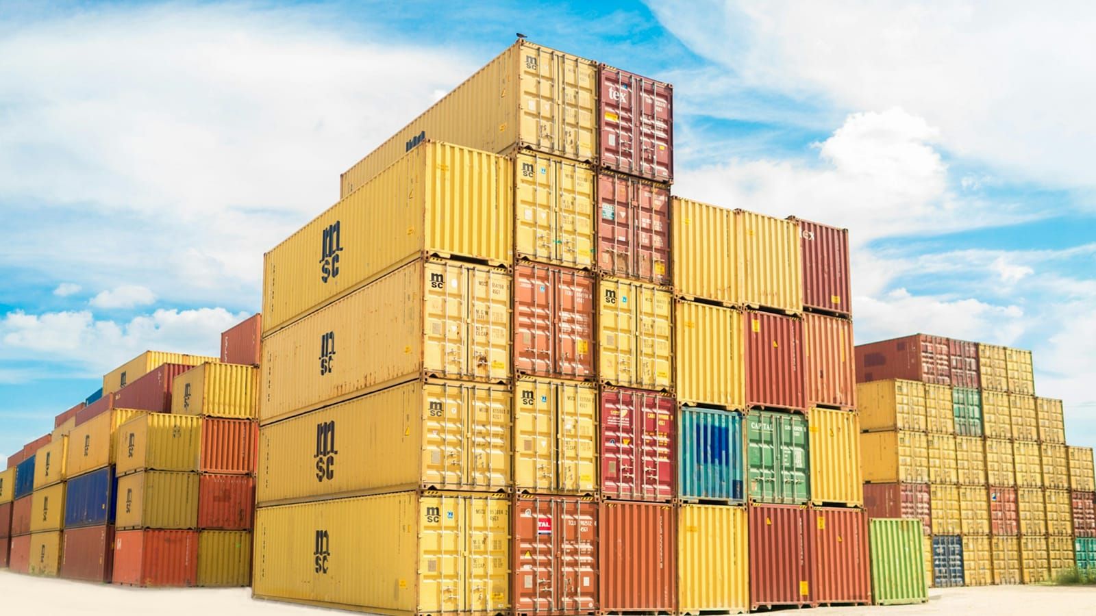 Stacked, colourful shipping containers under a blue sky